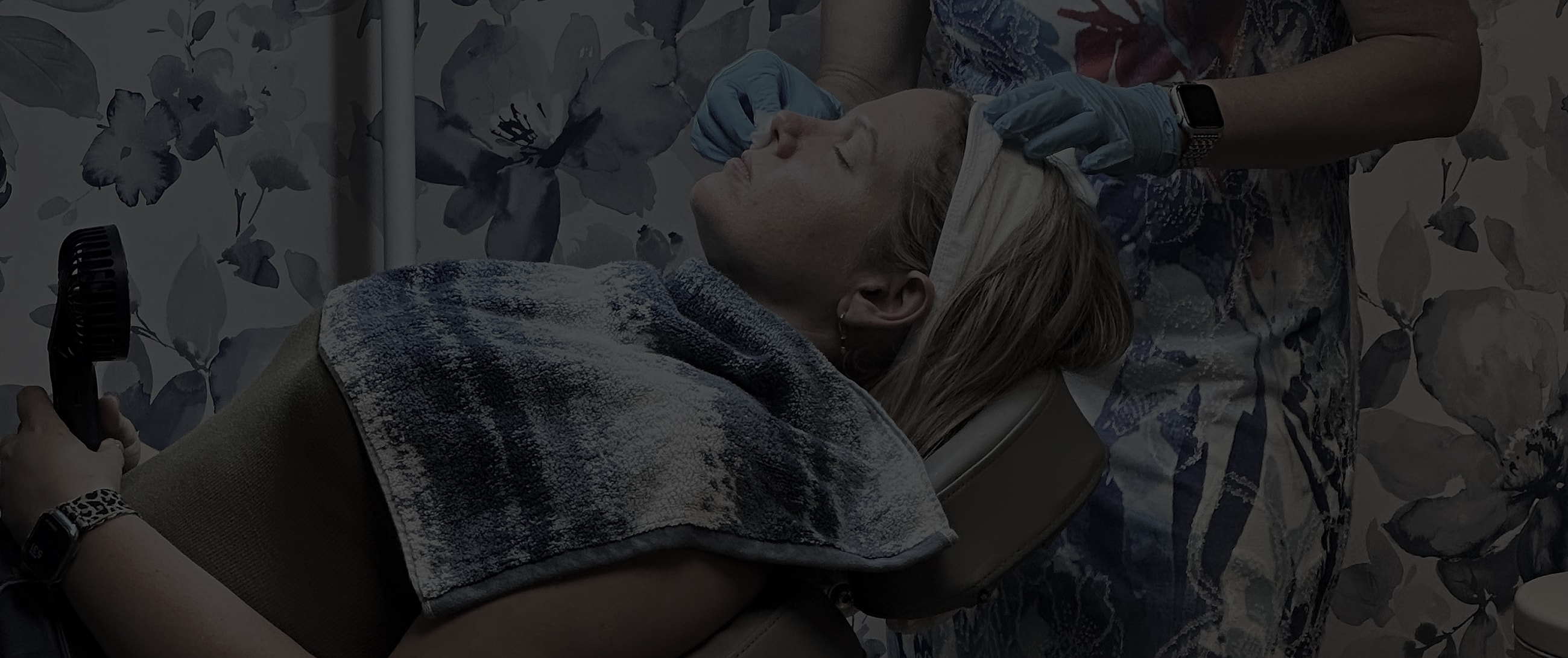 Woman receiving facial treatment in serene setting.