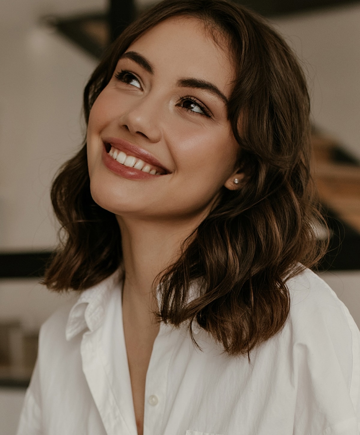 Smiling woman in a white shirt indoors.