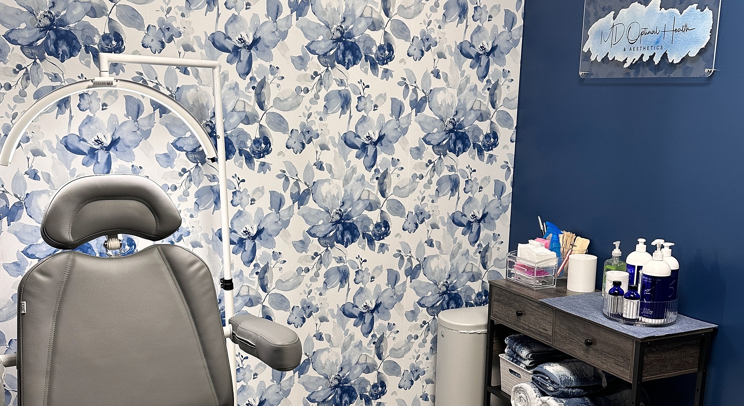 Aesthetic treatment room with floral wallpaper design.