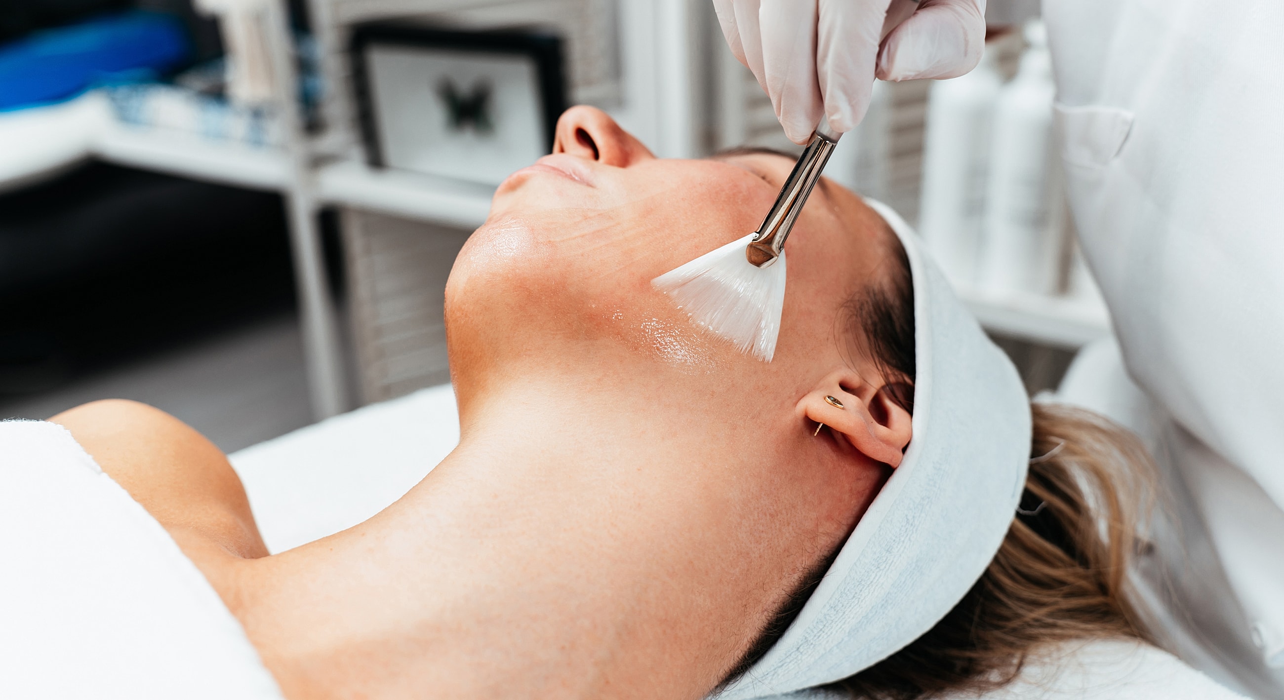 Applying facial treatment in a skincare session.