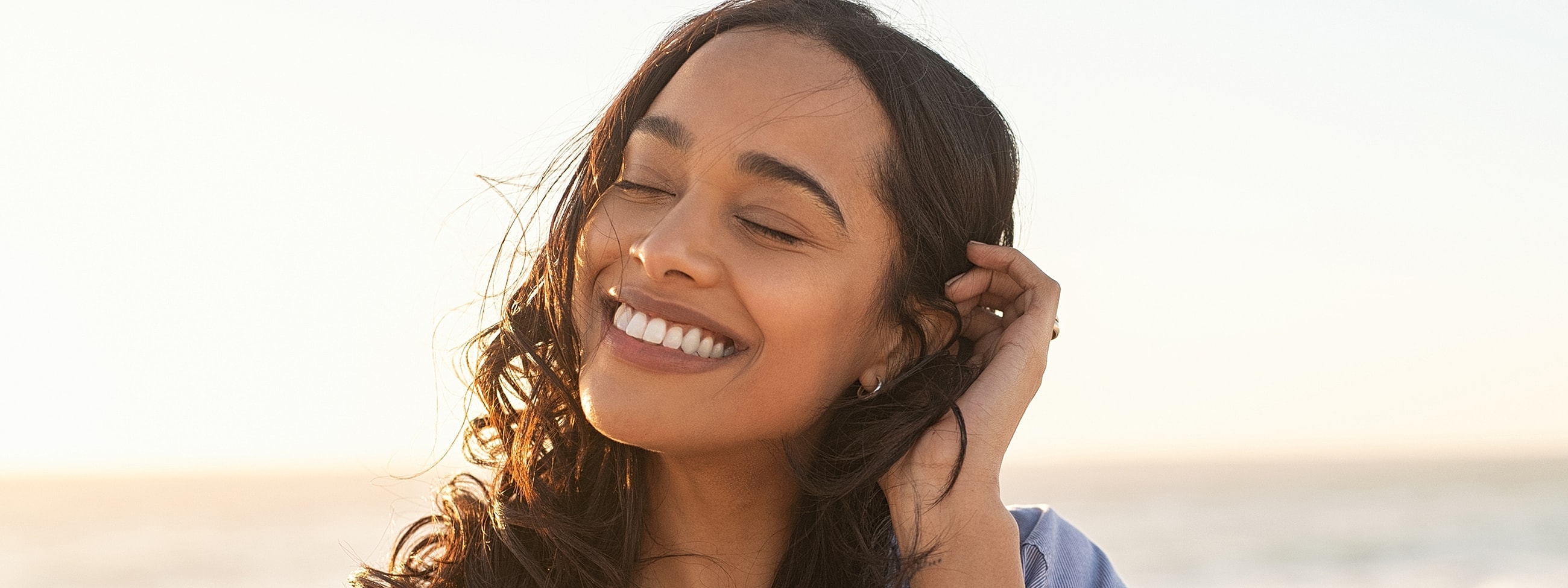 Smiling woman enjoying the beach at sunset.