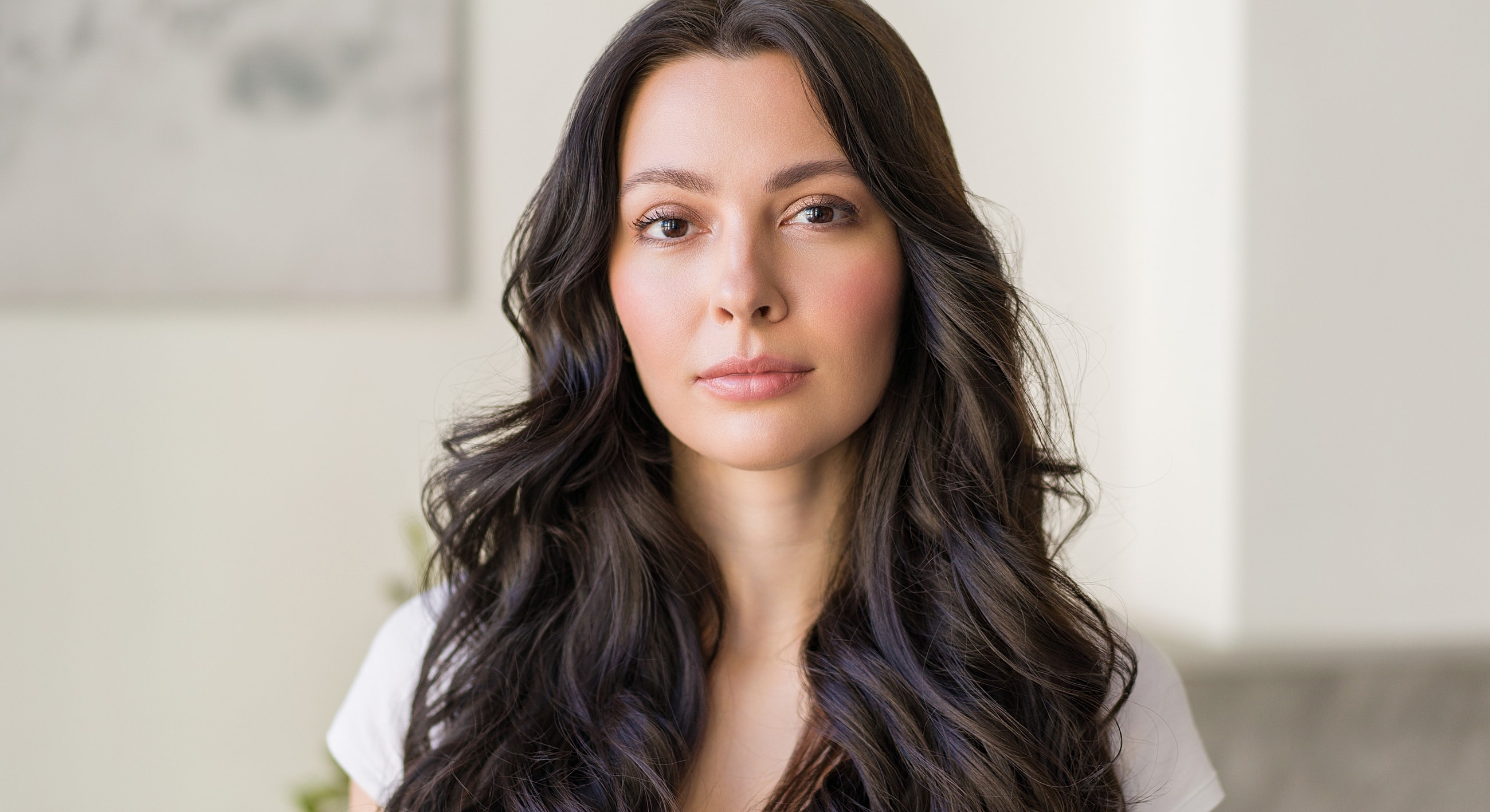 Woman with long dark hair, serious expression.