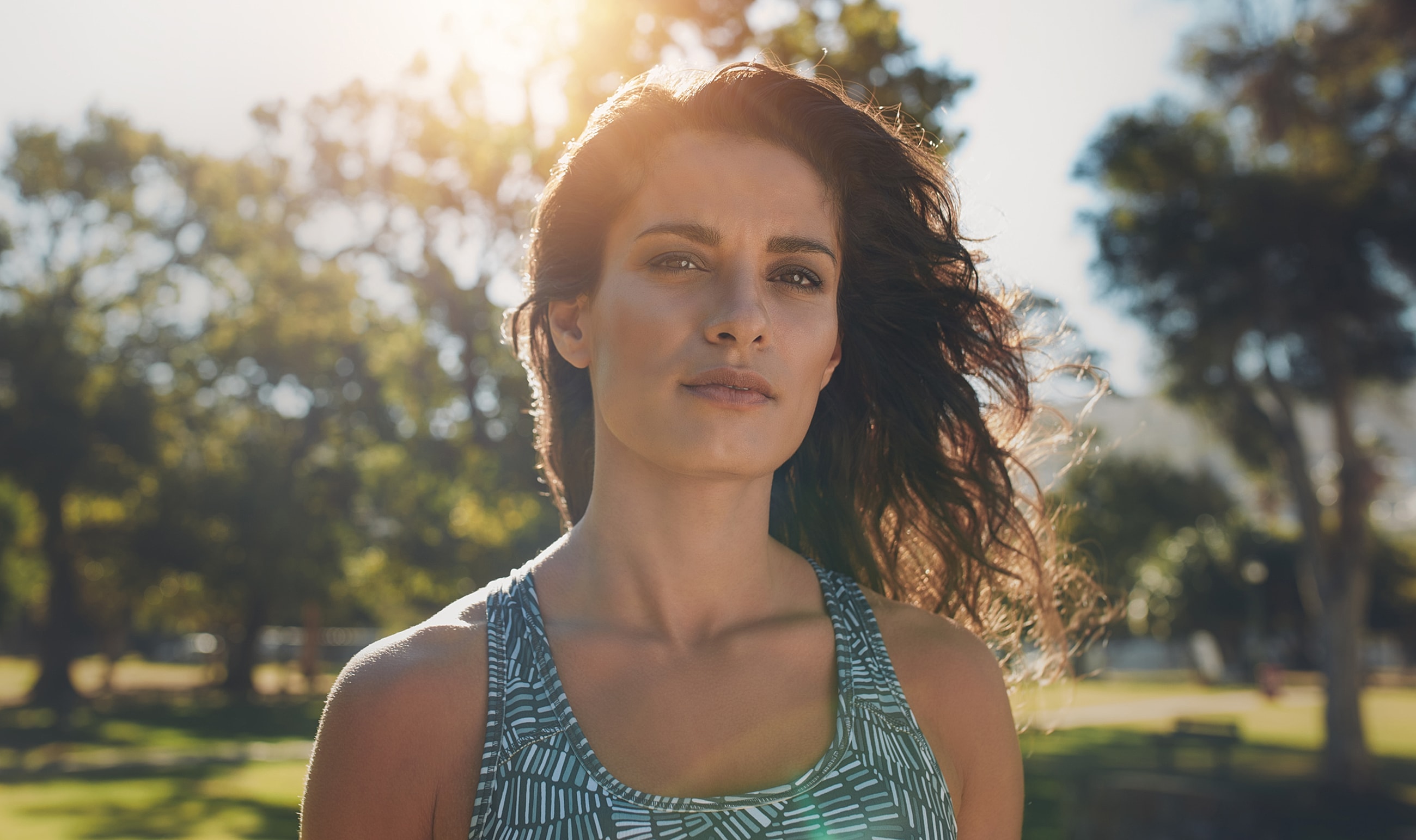 Woman outdoors with sunlight and breeze.